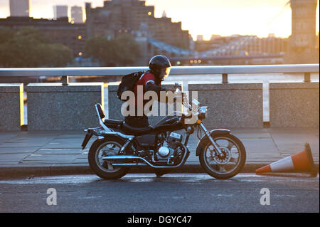 London, UK - 28. Oktober 2013: ein Mann schiebt sein Motorrad auf der Londoner Brücke, als die Stadt von dem Sturm getroffen wird. Der Sturm, genannt St. Jude, brachte das windigste Wetter Großbritannien seit 1987 getroffen.  Bildnachweis: Piero Cruciatti/Alamy Live-Nachrichten Stockfoto