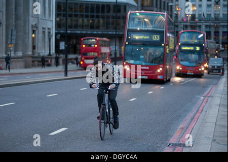 London, UK - 28. Oktober 2013: ein Mann über London Brücke auf ein Fahrrad kämpft mit starkem Wind, wie die Stadt von dem Sturm getroffen wird. Der Sturm, genannt St. Jude, brachte das windigste Wetter Großbritannien seit 1987 getroffen.  Bildnachweis: Piero Cruciatti/Alamy Live-Nachrichten Stockfoto