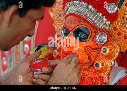 Malen das Gesicht der Theyyam Performer, Vorbereitung für ein Ritual, in der Nähe von Kasargod, North Kerala Süd-Indien, Asien Stockfoto