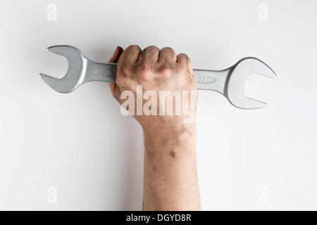 Eine Faust einen Schraubenschlüssel triumphierend hochhalten Stockfoto