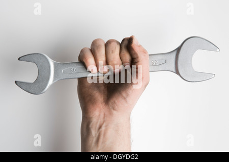 Eine Hand, einen Schraubenschlüssel triumphierend hochhalten Stockfoto