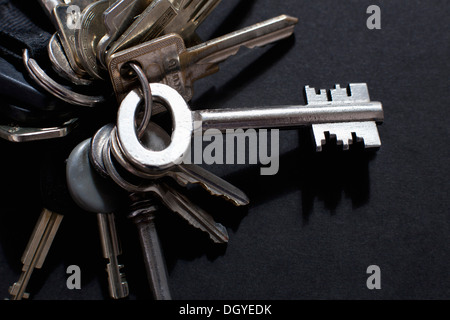 Ein merkwürdig geformte altmodischen Schlüssel ragte aus einem Schlüsselring von verschiedenen anderen Tasten Stockfoto