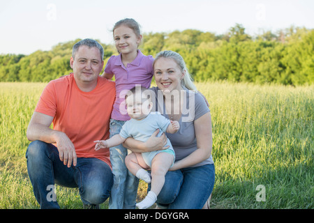 Ein Familienporträt genommen in einem Feld in einer ländlichen Umgebung Stockfoto