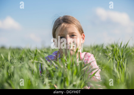 Ein lächelndes Mädchen an einem Sommertag in der Wiese liegen Stockfoto