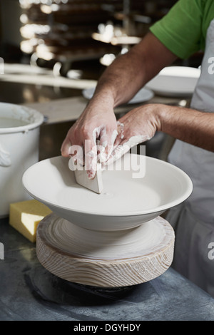 Ein Töpfer Formen einer Schale auf der Töpferscheibe Stockfoto