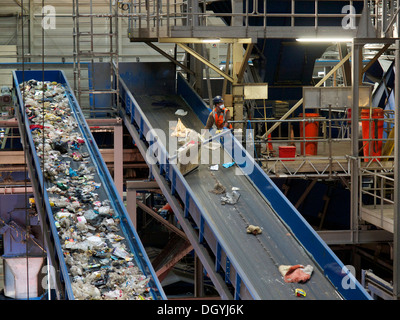 Mann im Hausmüll recycling-Anlage sortieren Müll auf Förderband von hand. Stockfoto