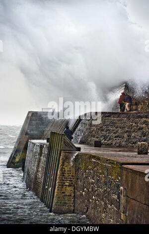 Porthcawl, South Wales, UK. 27. Oktober 2013. Touristen sind unter einer riesigen Welle bricht über den Deich in Porthcawl, Südwales (27. Oktober 2013) Sturm, genannt St. Jude, brachte das windigste Wetter, das Vereinigte Königreich seit 1987 treffen gefangen. © Adrian Sherratt/Alamy Live-Nachrichten Stockfoto