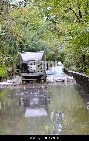 Lange Ashton, Bristol, UK. 28. Oktober 2013 Clarken Coombe in langen Ashton in der Nähe von Bristol gesehen überflutet einen lokalen Radfahrer und ein LKW durch Hochwasser nach St. Jude Storm zu verwalten. Der Sturm, genannt St. Jude, brachte das windigste Wetter, das Vereinigte Königreich seit 1987 Kredit treffen: Robert Timoney/Alamy Live News Stockfoto