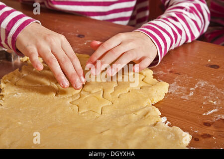 Hände des Kindes Ausschneiden von cookies Stockfoto