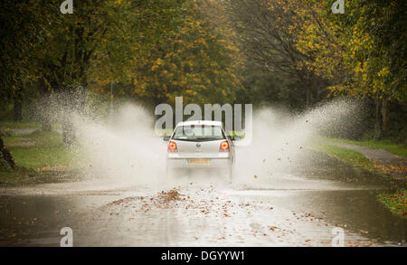 Bristol, UK 28. Oktober 2013. Ein Auto wirft Spray, wie es geht durch einen überfluteten Teil einer Straße entlang Clifton Downs in Bristol folgende Stürme über Nacht und heute Morgen. Windböen bis zu 99mph wurden in Großbritannien aufgenommen, als die südliche Hälfte des Landes von schweren Sturm Wetter getroffen wurde. Der Sturm, genannt St. Jude, brachte das windigste Wetter Großbritannien seit 1987 getroffen. Bildnachweis: Adam Gasson/Alamy Live-Nachrichten Stockfoto