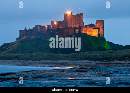 Bamburgh Castle beleuchtet in der Abenddämmerung, Bamburgh, Northumberland, England, Vereinigtes Königreich Stockfoto