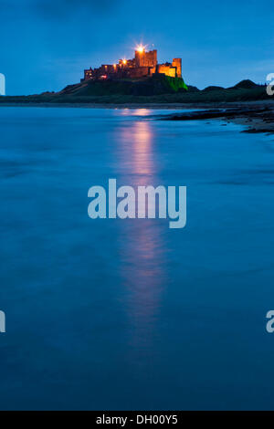 Bamburgh Castle beleuchtet in der Abenddämmerung, Bamburgh, Northumberland, England, Vereinigtes Königreich Stockfoto