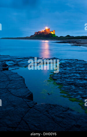 Bamburgh Castle beleuchtet in der Abenddämmerung, Bamburgh, Northumberland, England, Vereinigtes Königreich Stockfoto