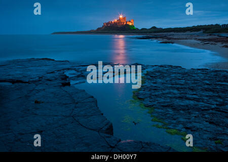 Bamburgh Castle beleuchtet in der Abenddämmerung, Bamburgh, Northumberland, England, Vereinigtes Königreich Stockfoto