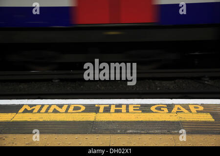 Gelbe Markierung MIND THE GAP auf dem Boden einer Station der Londoner U-Bahn, Zug, London, London Region, England Stockfoto