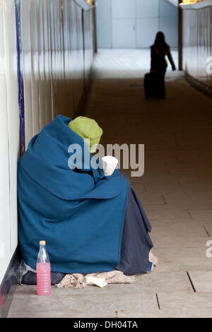 Obdachloser, eingewickelt in eine Decke sitzen in einer Unterführung, London, London Region, England, Vereinigtes Königreich Stockfoto