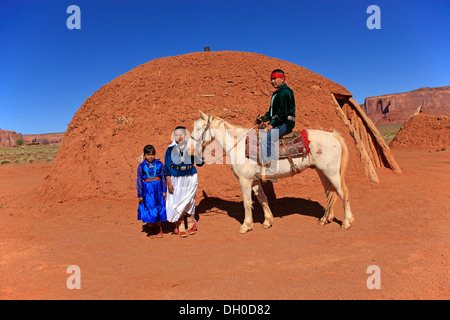 Navajo indische Familie mit einem Pferd vor einem Navajo-Hogan, ein landestypisches Haus, Monument Valley, Utah, Vereinigte Staaten von Amerika Stockfoto