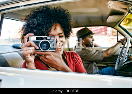 Frau mit Vintage-Kamera im Auto Stockfoto