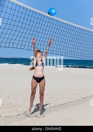 Attraktive Frau spielt im Beach-volleyball Stockfoto