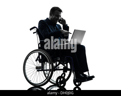 einem behinderten Geschäftsmann computing Laptop-Computer im Silhouette Studio auf weißem Hintergrund Stockfoto
