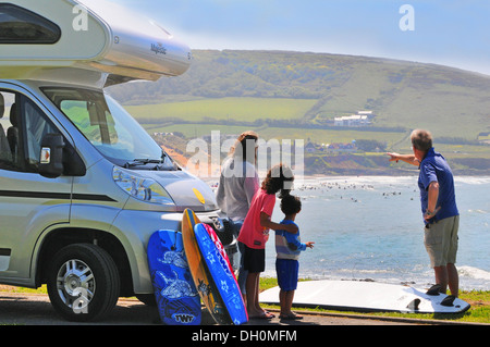 Großeltern weisen auf die sichersten und besten Surfgebiete für die Enkelkinder in Croyde Bay, North Devon, England, Großbritannien Stockfoto