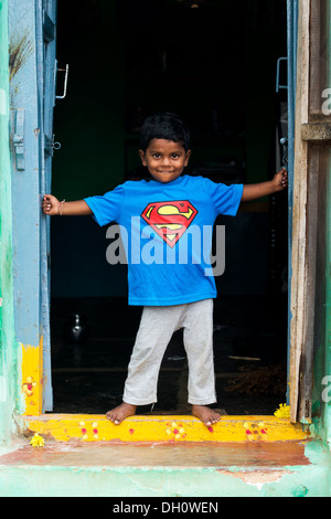 Jungen tragen ein Superman-t-Shirt-steht in der Tür seines Hauses in einem indischen Dorf. Andhra Pradesh, Indien Stockfoto