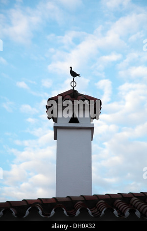 Schornstein über Dach mit Vogel Wetterfahne Stockfoto