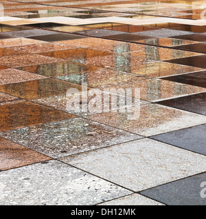 Regen Pfützen auf Stein Fliesen von urbaner Platz Stockfoto