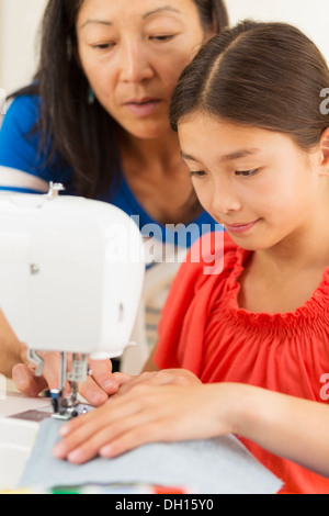 Mutter Lehre Mädchen um die Nähmaschine verwenden Stockfoto