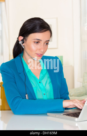 Gemischte Rassen Geschäftsfrau trägt Kopfhörer und Laptop verwenden Stockfoto