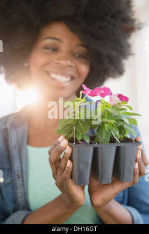 Gemischte Rassen Frau hält Topfpflanzen Blumen Stockfoto