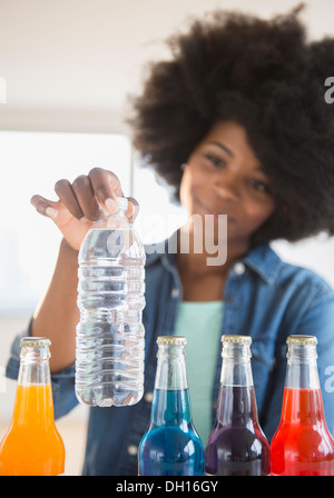 Gemischte Rassen Frau Wahl Wasser über soda Stockfoto