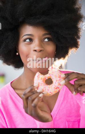 Gemischte Rassen Frau Essen donut Stockfoto