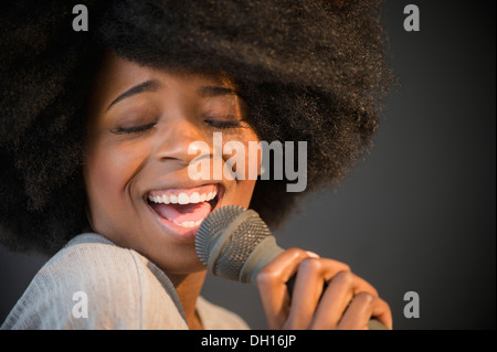 Gemischte Rassen Frau ins Mikrofon singen Stockfoto