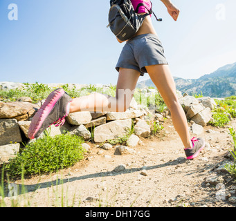 Kaukasische Frau läuft auf felsigen Pfad Stockfoto