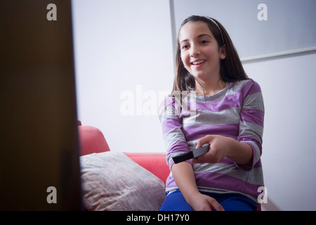 Hispanischen Mädchen vor dem Fernseher auf sofa Stockfoto