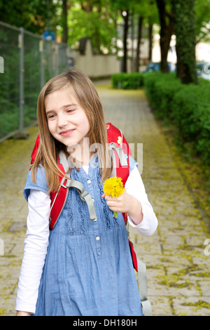 Kleines Mädchen Heimweg von der Schule, hält eine Blume, München, Bayern, Deutschland Stockfoto