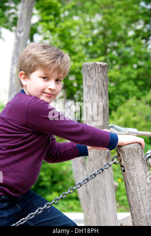 Junge spielt auf Klettergerüst auf dem Spielplatz, München, Bayern, Deutschland Stockfoto