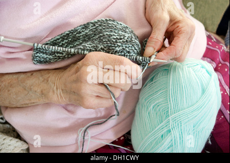 Ältere Frau eine Kleidungsstück stricken - stricken ist nicht nur ein großartiges Hobby / Interesse aber hilft das Gehirn aktiv zu halten. Diese Rentner hat schlechte arthritiritis Stockfoto