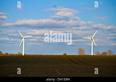 Zwei Windkraftanlagen in einem Feld gegen bewölktem Himmel, Dänemark, Europa Stockfoto