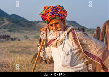 Kamel Händler nimmt eine Pause von der Fahrt seinen Kamelen durch die Wüste Thar auf dem Jahrmarkt in Pushkar, Rajasthan, Indien. Stockfoto
