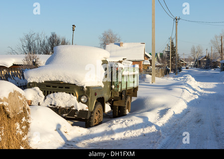 Ein einsamer alter LKW auf der Straße Wintertag. Stockfoto
