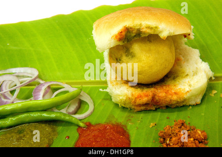 Vada Pav mit roten Chutney grüne kühl Zwiebeln auf grünen Bananenblatt Stockfoto