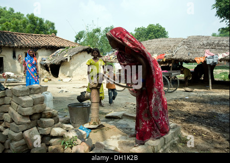 Frau pumpt Wasser aus der Handpumpe Borewell Varanasi Uttar Pradesh Indien Asien Stockfoto