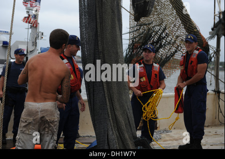 Theran Thomas, ein Matrose an Bord des Bootes 88-Fuß Garnelen Meerkönigs, hilft Küste Gardisten Ausrüstung weggeräumt Dienstag, 15. Oktober 2013 am Safe Harbor Marina in Atlantic Beach, Florida Eine Küstenwache Boatcrew von Station Mayport in Atlantic Beach reagiert nach Stockfoto