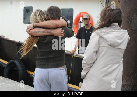 Brooke Peaver umarmt ihr Freund Theran Thomas, ein Matrose an Bord des Bootes 88-Fuß Garnelen Meerkönigs, fing an, am Wasser und in der Gefahr des Sinkens aus Ponte Vedra, Florida, Dienstag, 15. Oktober 2013. Eine Küstenwache Boatcrew von Station Mayport in Stockfoto