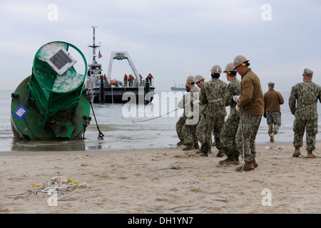Marine Segler aus amphibischen Bau-Bataillon 2, Beachmaster Unit 2 und Marine Beach Gruppe 2 gemeinsame Expeditionary Base Little Creek arbeitslos mit der Küstenwache, zwei gewaschen-an Land zu entfernen Bojen vom Strand und mit Meerblick Chic Gebieten von Virginia B Stockfoto