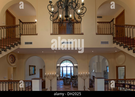 Große offene Halle mit doppelten Treppen zur Landung in spanische Villa mit schmiedeeisernen Kronleuchter Galerie Stockfoto