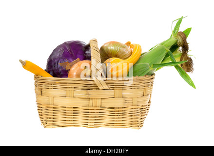 Mais, Kürbisse, Zwiebeln und Rotkohl in einem alten Weidenkorb auf weißem Hintergrund. Stockfoto