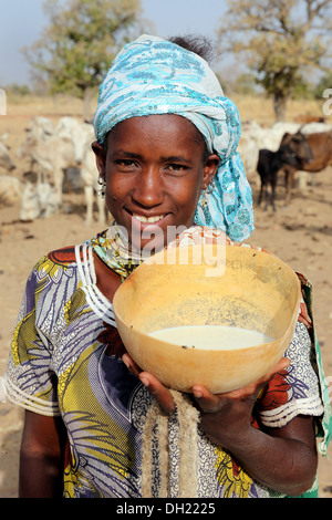 Eine Fulbe-Frau präsentiert Kalebasse mit frischer Milch, Burkina Faso Stockfoto